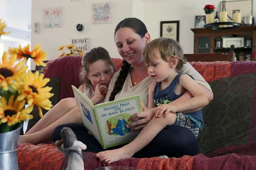 mom with anxiety reading a book to her two kids