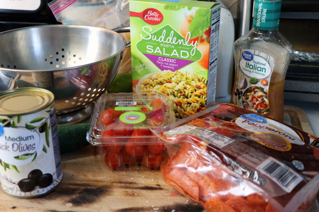 ingredients needed to make pasta salad sitting on the kitchen counter