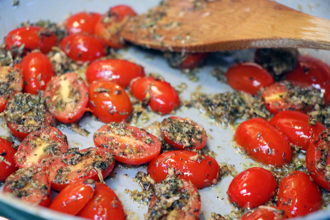 cherry tomatoes and italian seasoning cooking in a pan