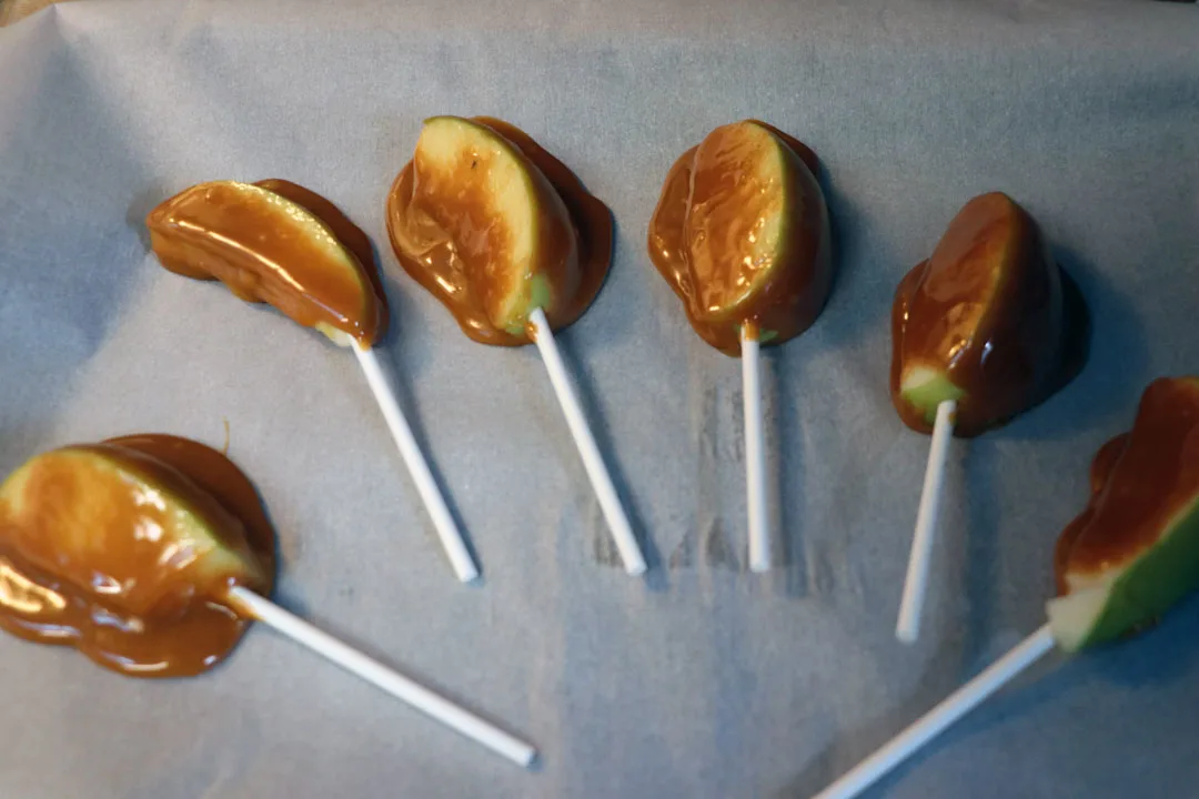 caramel apples on a sick on parchment paper