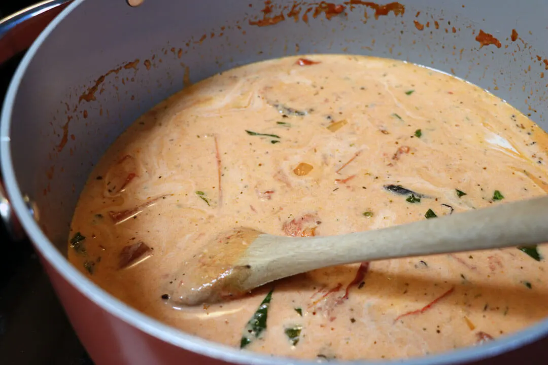 creamy tomato basil soup in a dutch oven on the stove still chunky