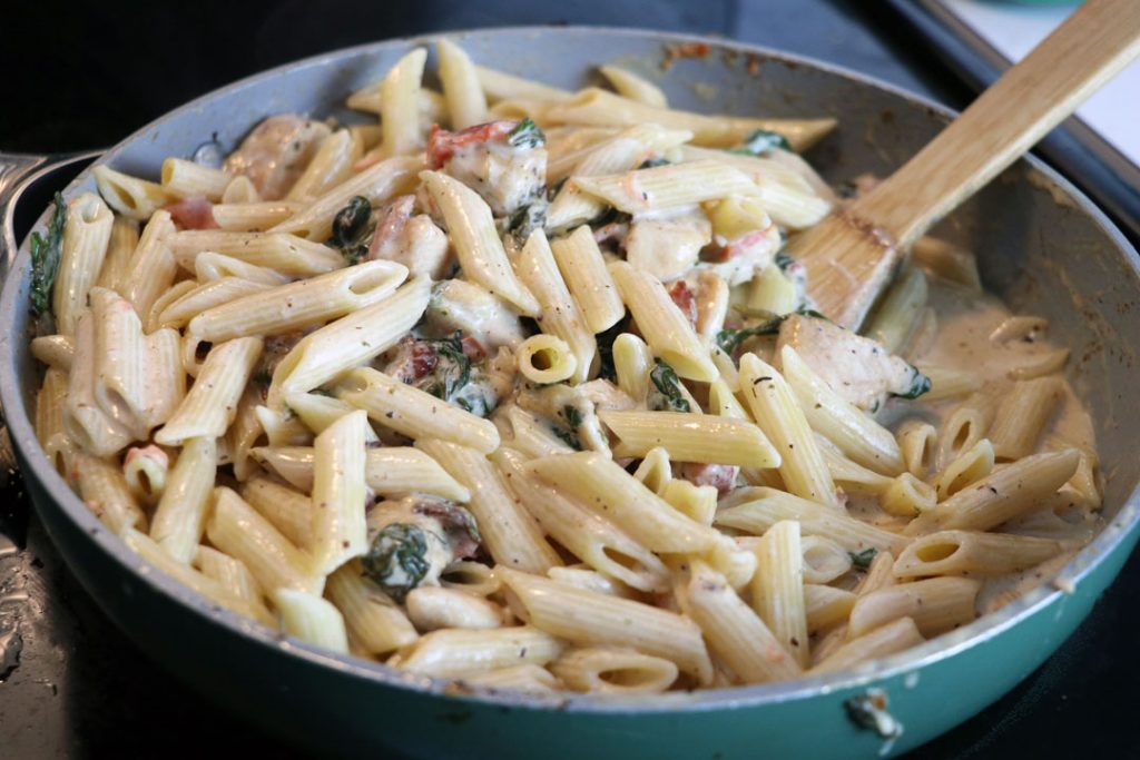 Creamy chicken and bacon pasta in a pan on the stove