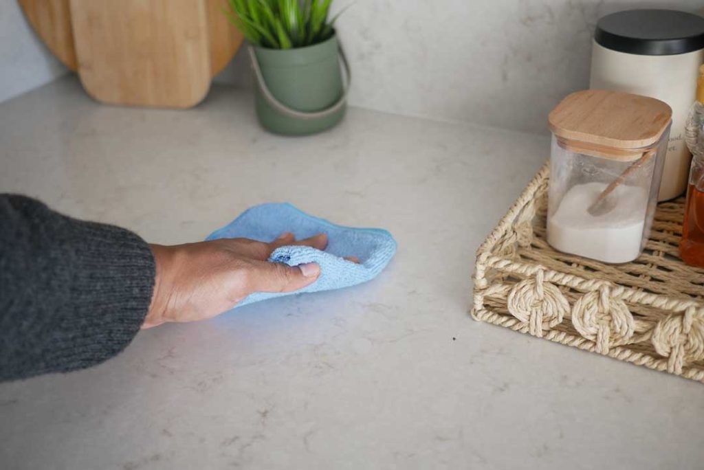 Cleaning kitchen counter with microfiber cloth for daily maintenance