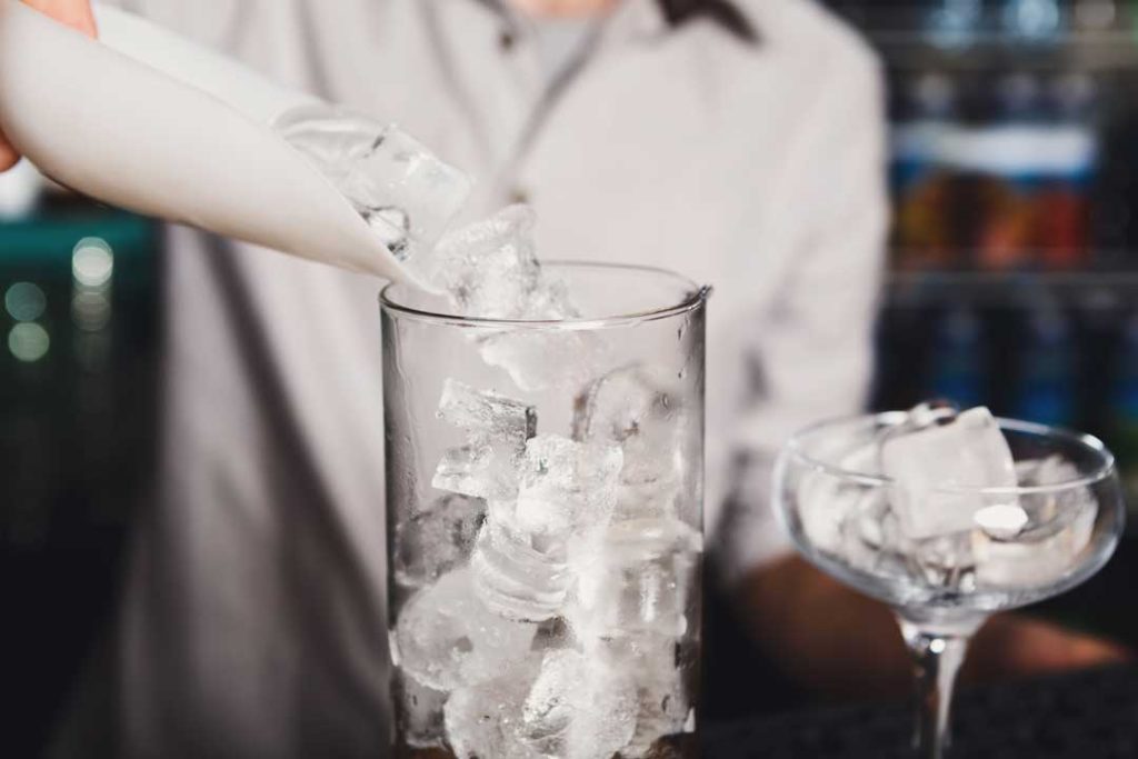 Bartender using ice from a high-capacity commercial ice machine