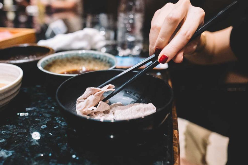Bowl of steaming ramen with chopsticks resting neatly on the side