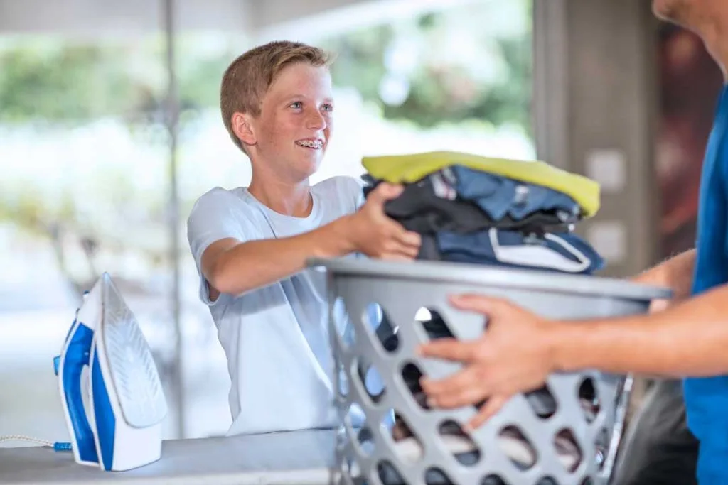 Child helping fold laundry at home