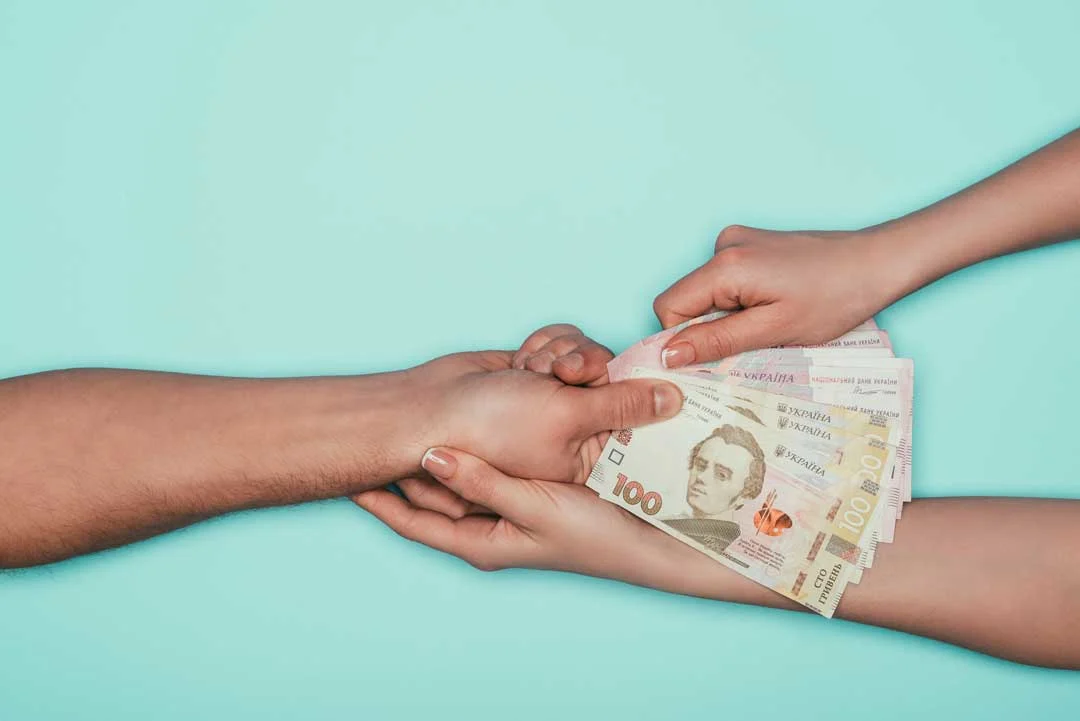 Hands exchanging international currency
