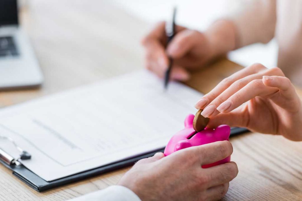Hands signing a document with a notary stamp.