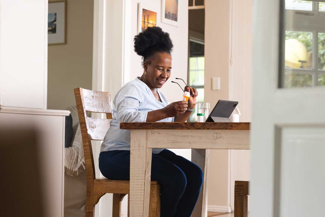 Mom working at kitchen table with laptop and planner