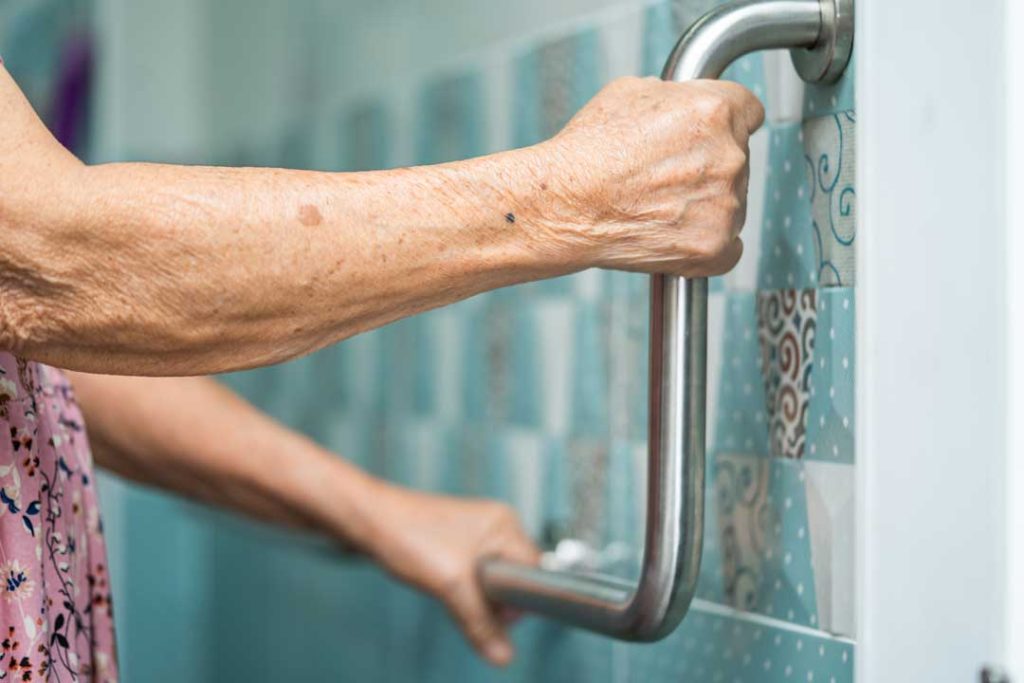 Older adult using grab bar in bathroom