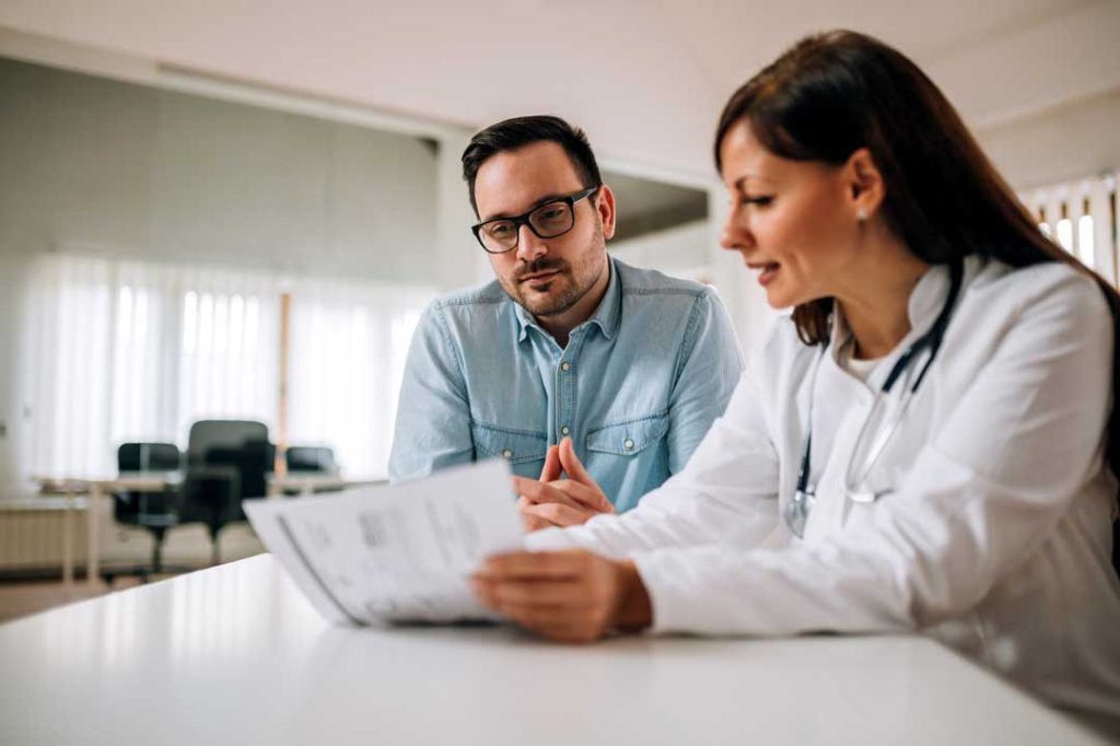 Patient reviewing insurance with a medical professional.