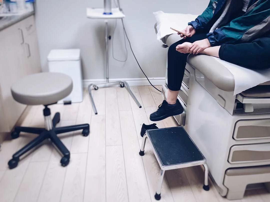 woman unsure if he fractured his ankle, waiting for an x-ray at urgent care.