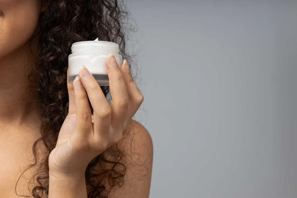 Person using a lightweight facial moisturizer for summer