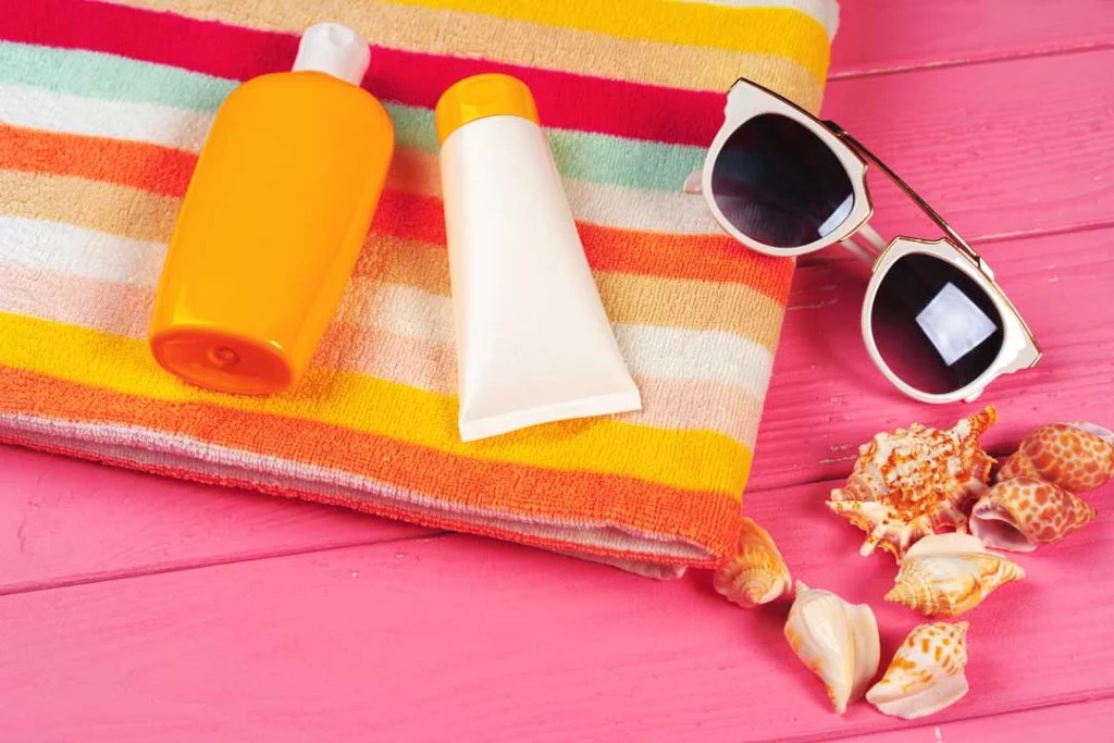 Various SPF sunscreen bottles laid out with summer accessories
summer skincare tips