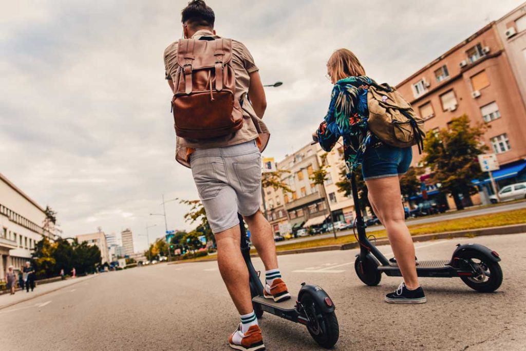 Tourists riding a scooter through a city