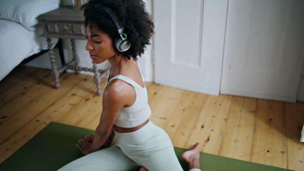 Woman in peaceful yoga pose with headphones