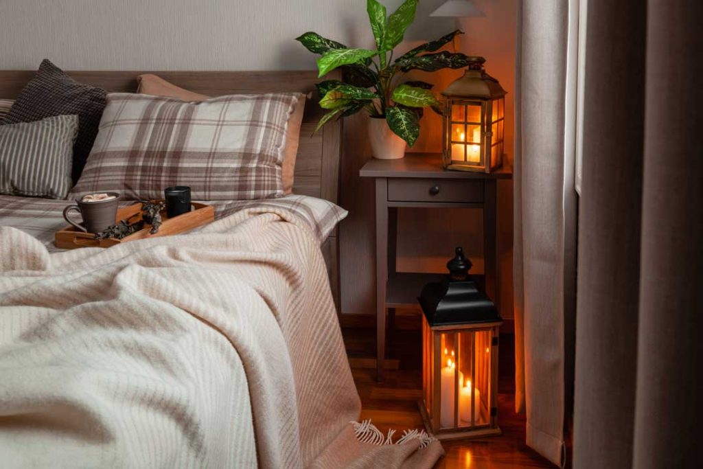 Bedroom corner with a reading lamp and cozy throw blanket
