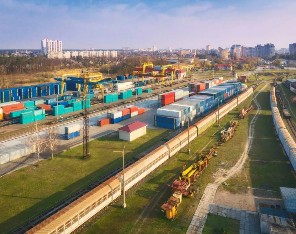 Cargo trucks and rail containers at a logistics facility