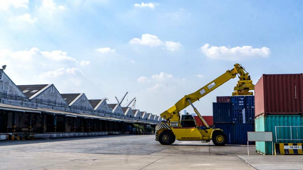 Forklift unloading cargo from rail to truck at intermodal terminal
