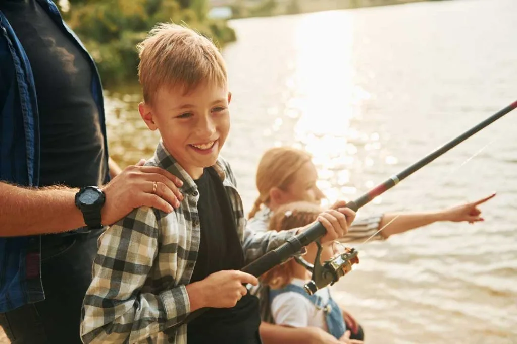 Close-up of children's hands holding appropriately sized fishing rods and reels, highlighting the importance of suitable gear for kids.