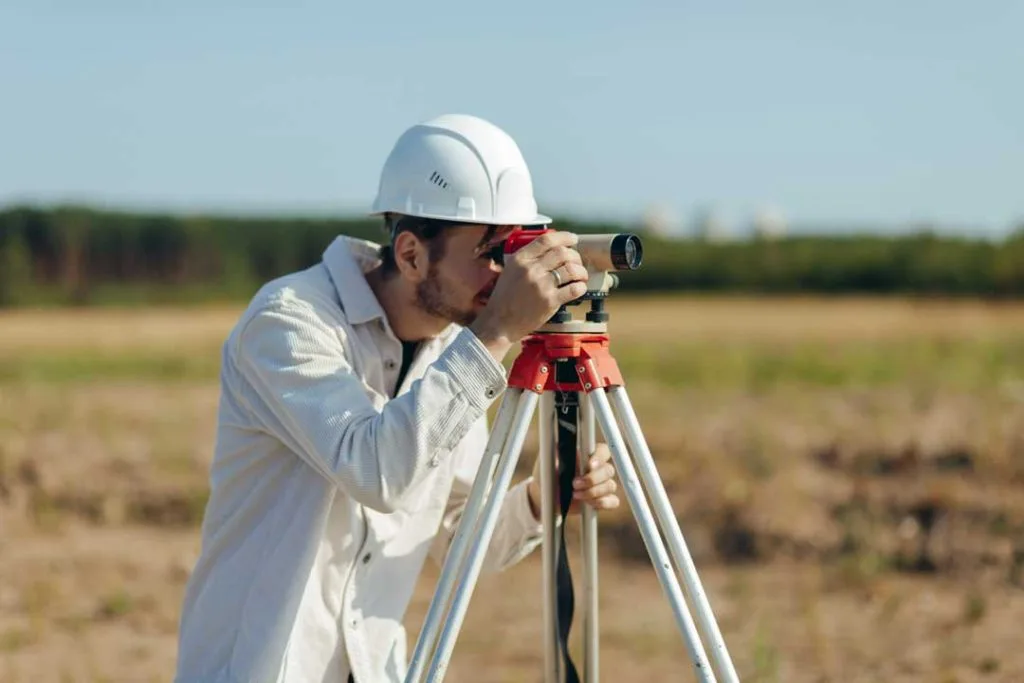 Land surveyor measuring property boundaries