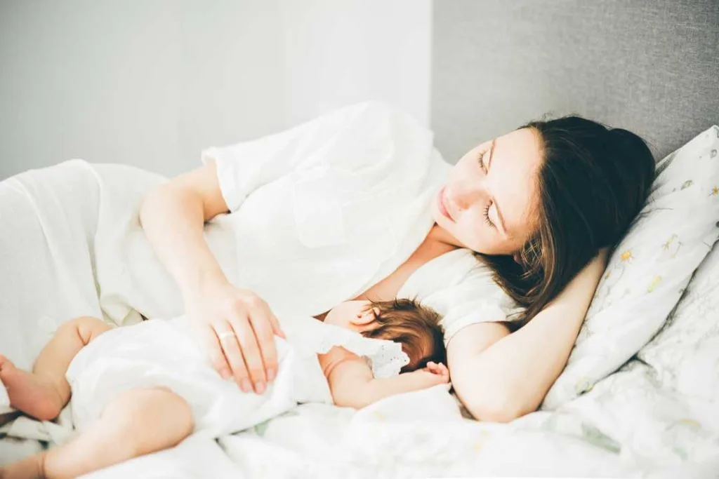 A peaceful image of a new mother resting in a comfortable position with her baby nearby, underscoring the importance of rest and patience in the C-section healing process