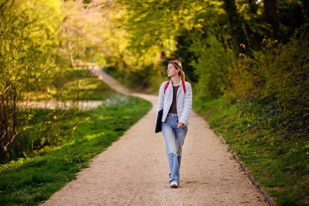 A person enjoying a calm morning walk outdoors, illustrating the benefits of early exercise for better sleep