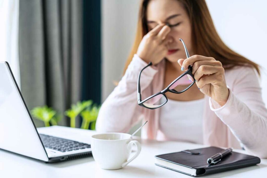 Tired person rubbing eyes after long screen use