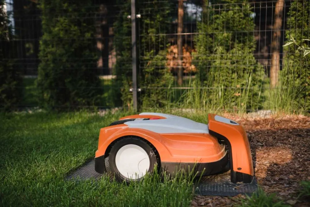 Robotic lawn mower trimming grass