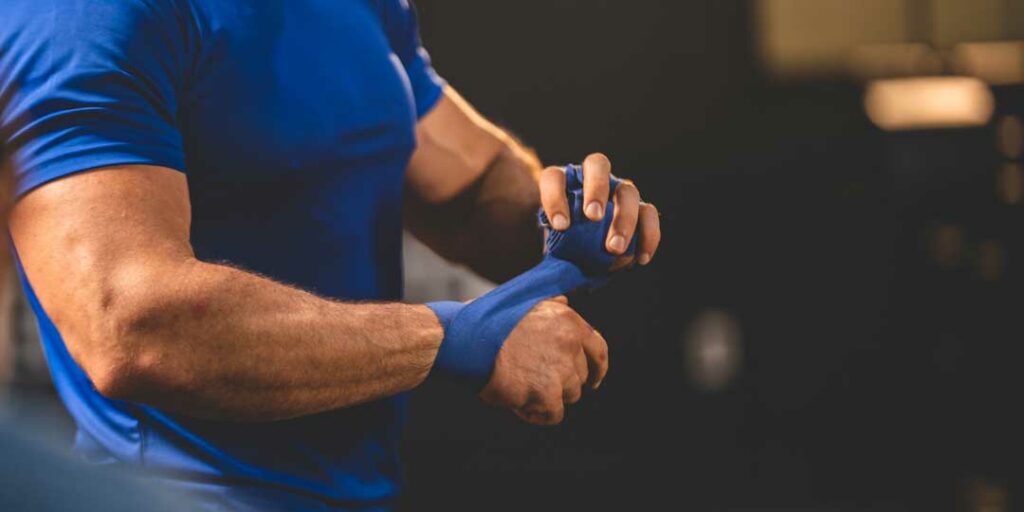 Trainer guiding weight lifter to prevent injury

