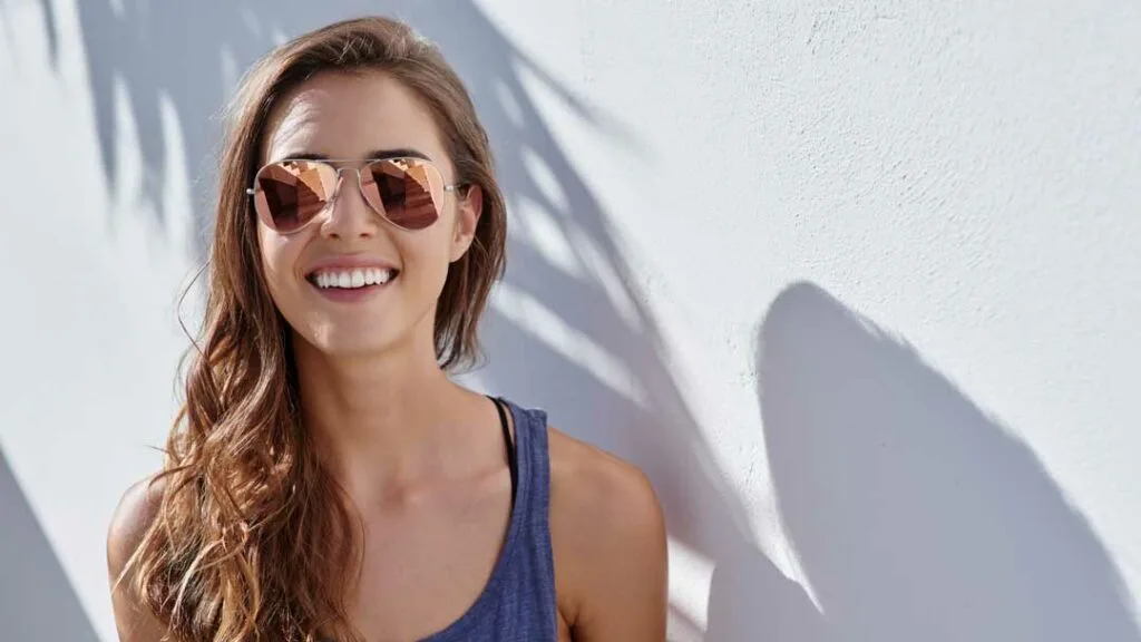 Woman smiling in the sun, wearing sunglasses