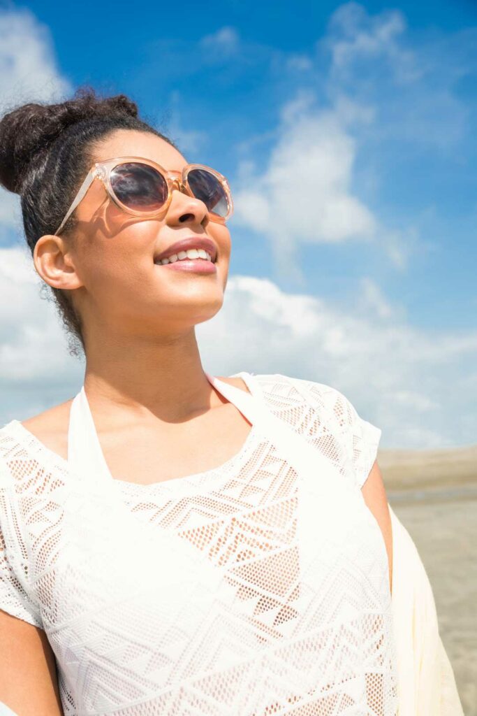 Happy woman outdoors with sunglasses, symbolizing eye wellness