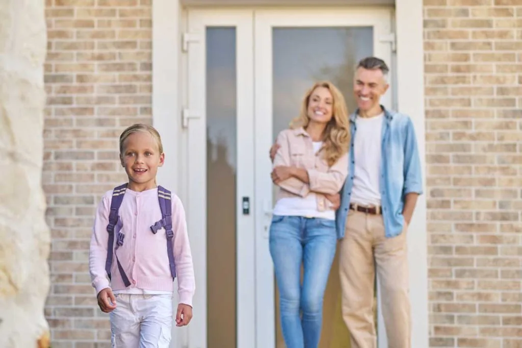 family standing outside their new home smiling