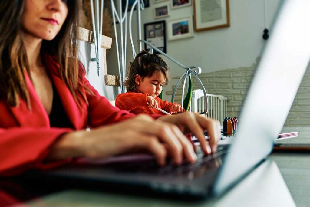Mom working from home while kids play in the background