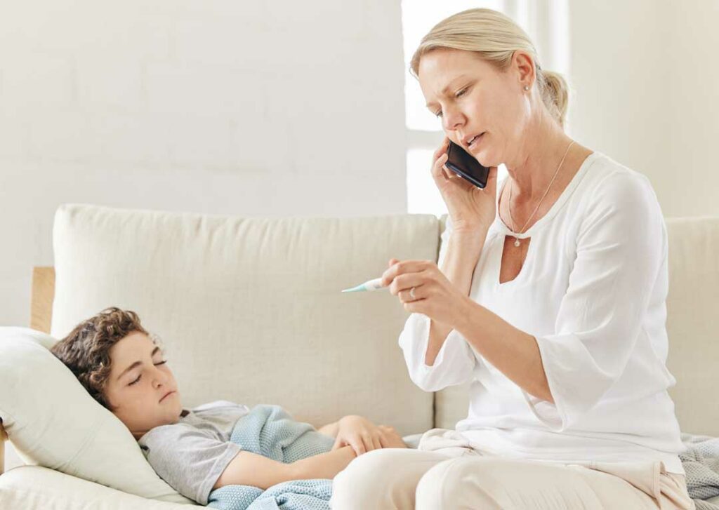 Concerned mother checking child’s temperature at home