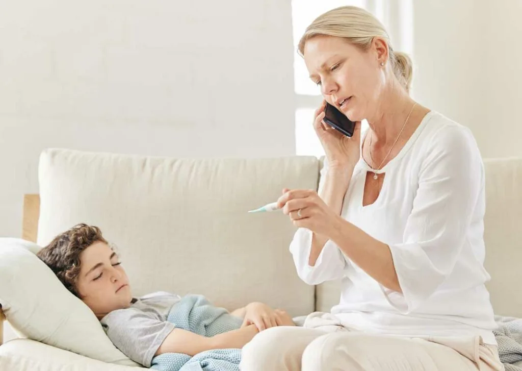 Concerned mother checking child’s temperature at home