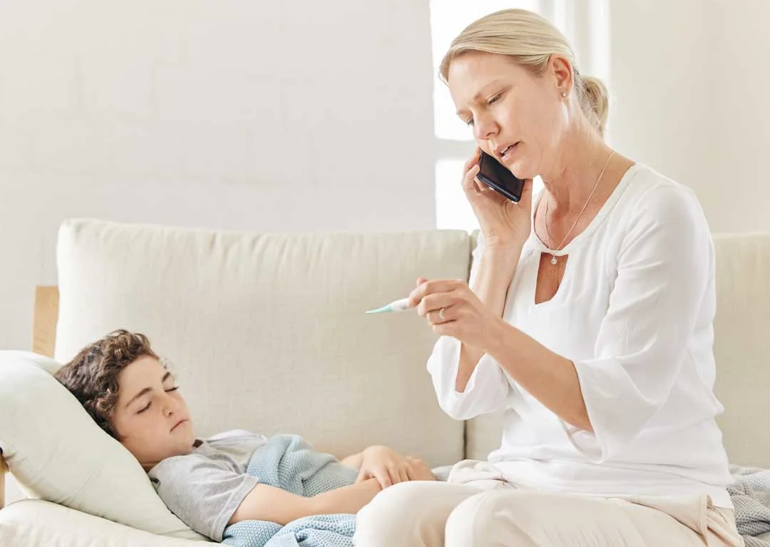 Concerned mother checking child’s temperature at home
