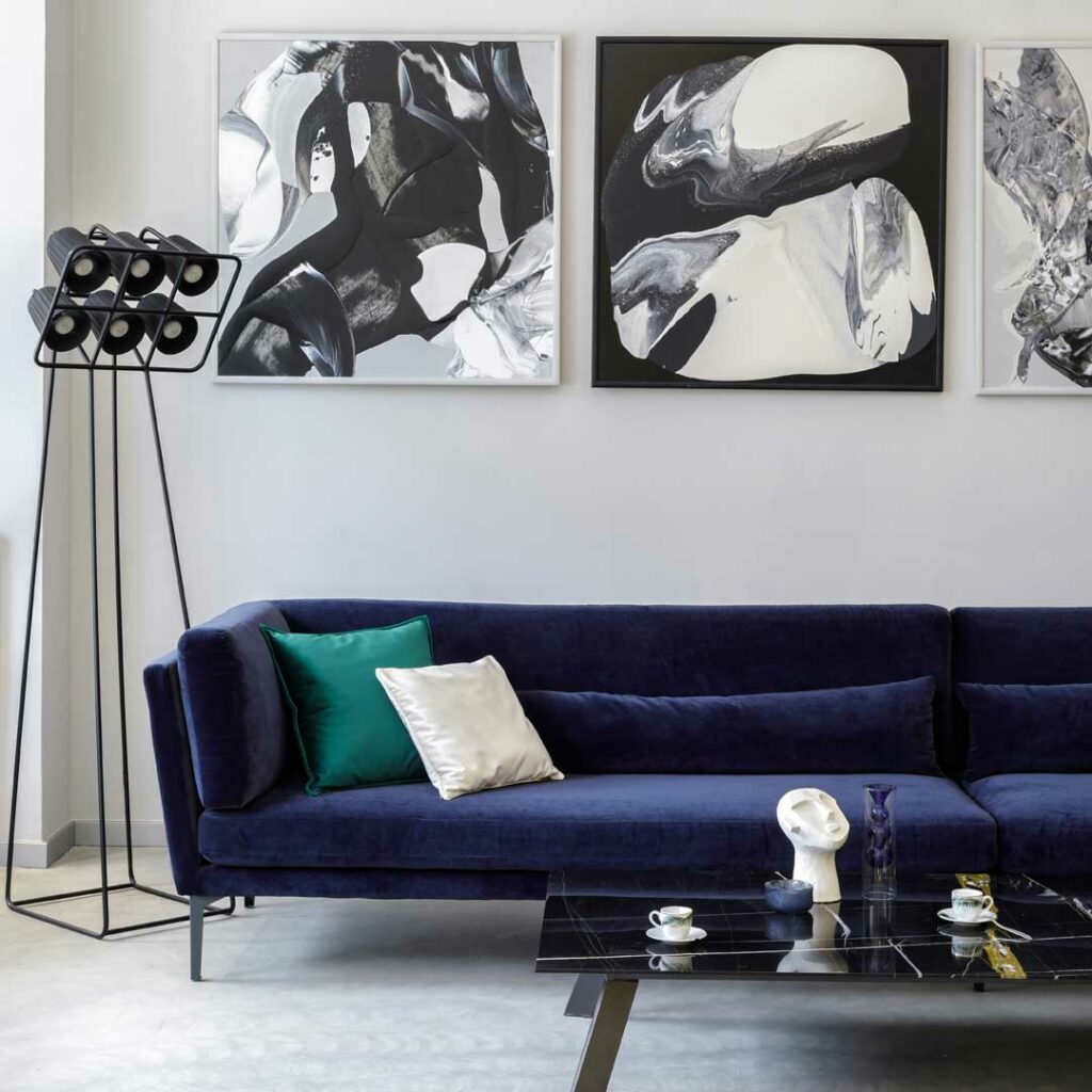 Sofa with statement art above and open-legged furniture