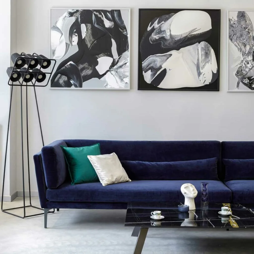 Sofa with statement art above and open-legged furniture