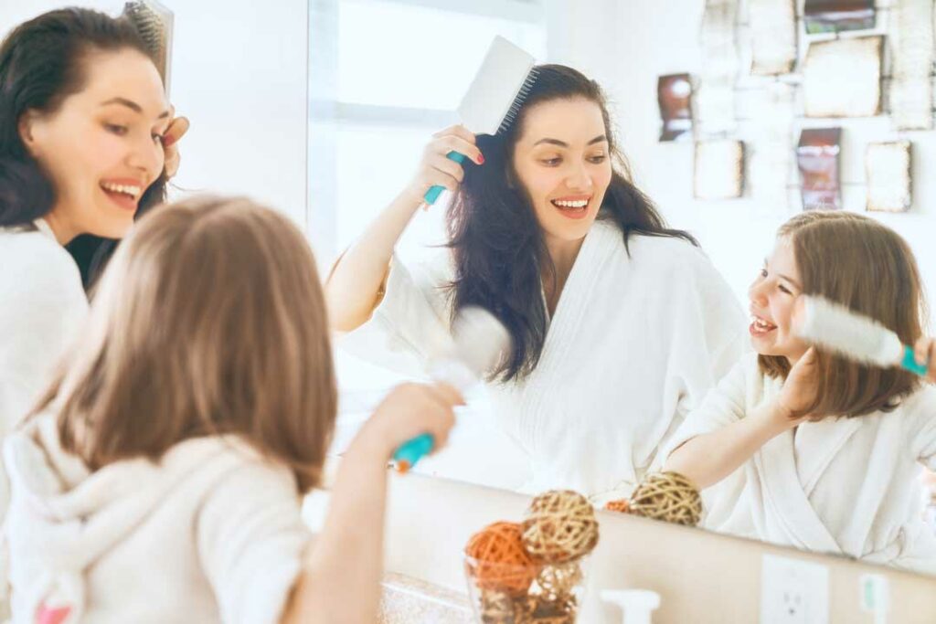 Busy mom doing her hair quickly in front of a mirror