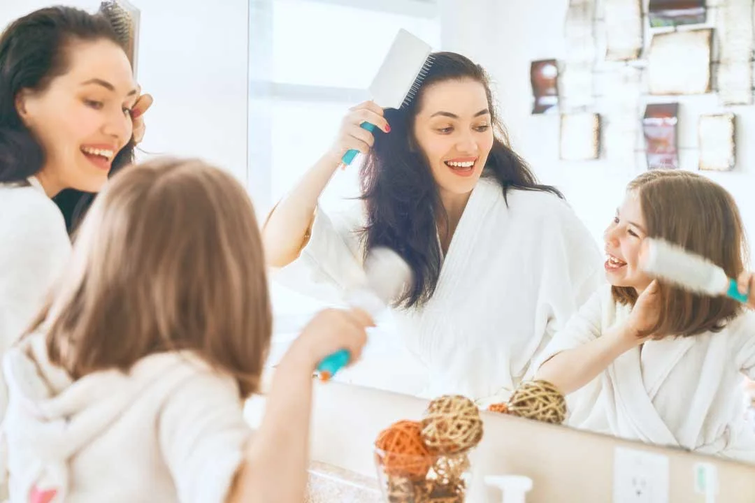 Busy mom doing her hair quickly in front of a mirror
