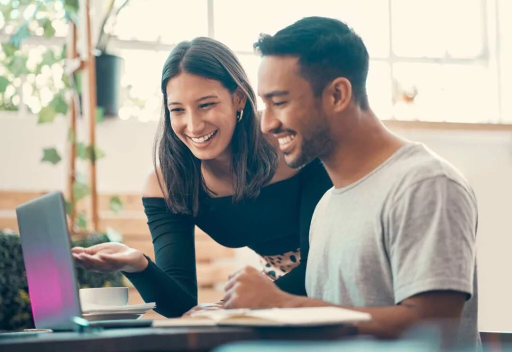 Couple smiling and reviewing finances together