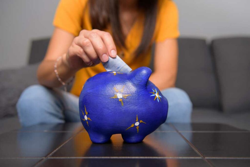 Happy person holding a piggy bank