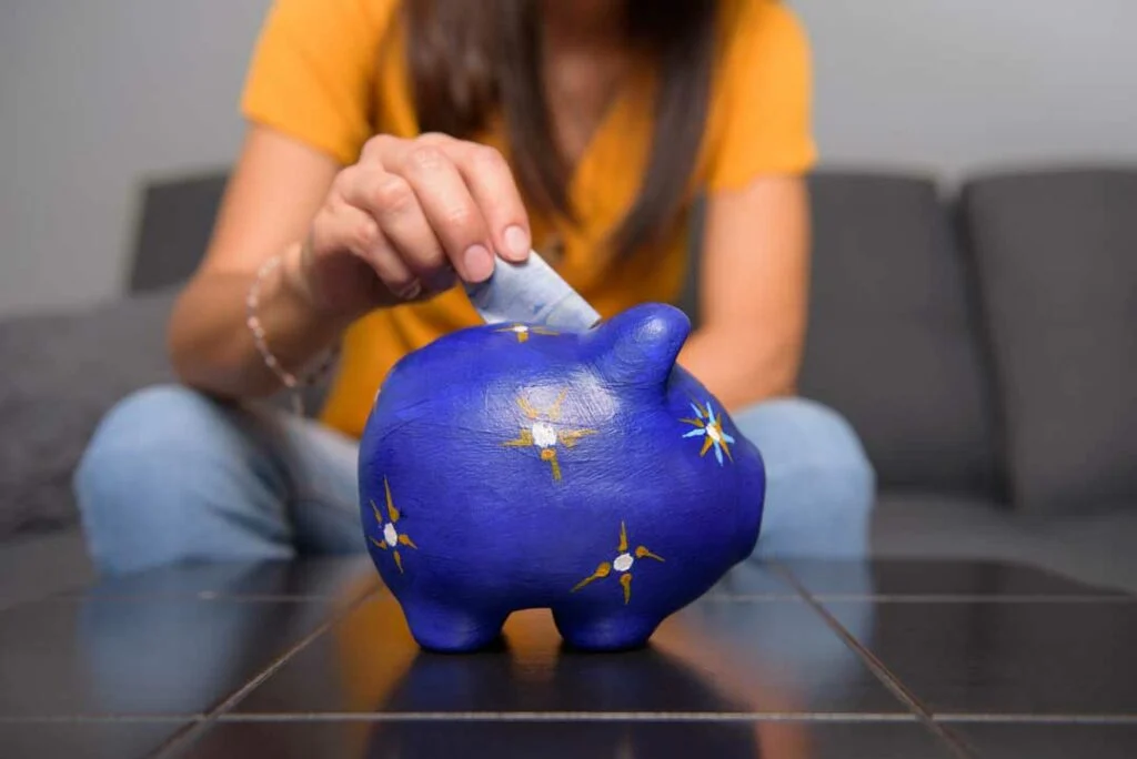 Happy person holding a piggy bank