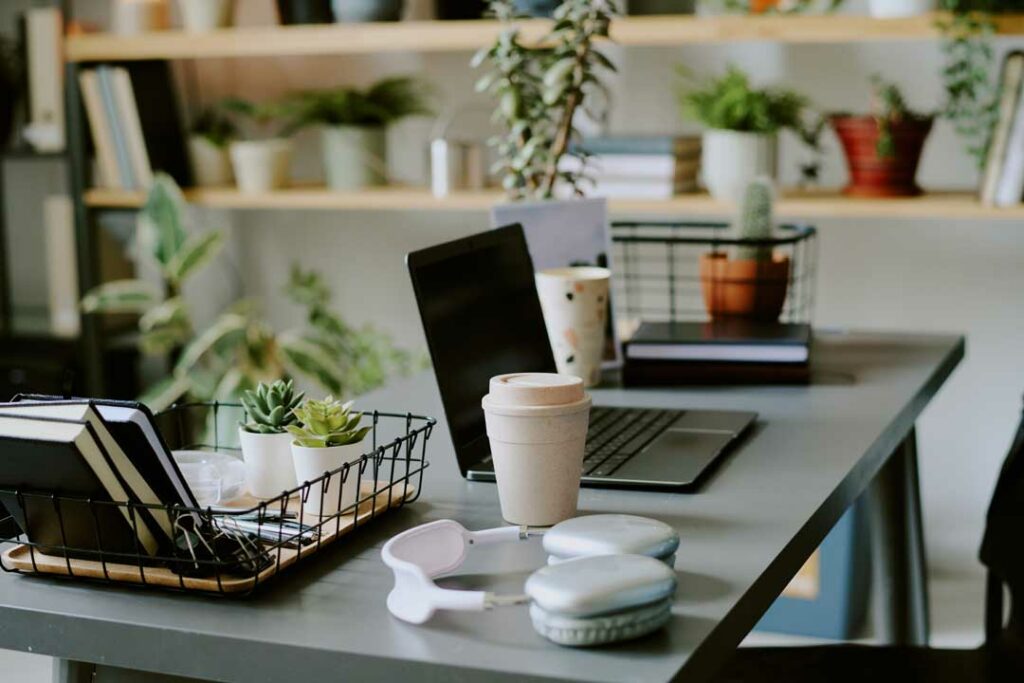 Organized desk with planner, coffee, and laptop in natural light