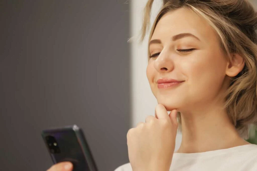 Woman using phone banking app with relaxed expression